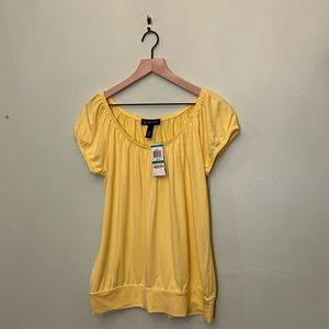 I. N. C. Daisy Yellow top 95% rayon 5% spandex label says petite L machine wash.